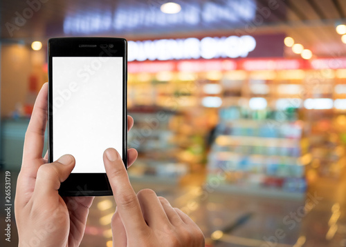 hand holding and using and touch screen smart phone on blurred background at supermarket store