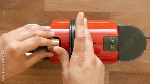 Top shot of espresso coffee maker. Mans hand put a capsule and mug and presses the button