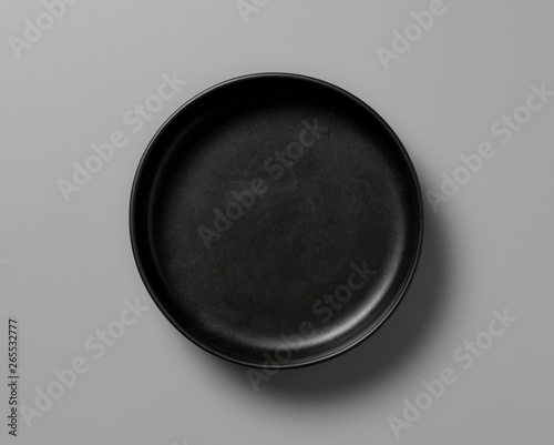 Top view empty black plate on grey background with shadow
