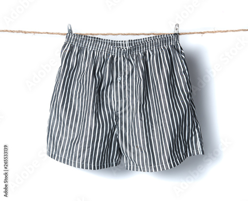 Men's boxer shorts hanging on rope isolated on white background