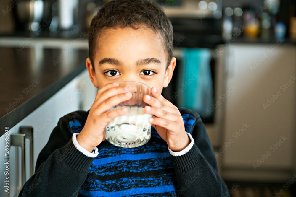 Cute African American boy drinking milk at home Stock Photo | Adobe Stock