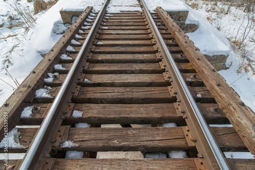 Wooden and steel railroad bridge in the rural snowy cold Minnesota winter
