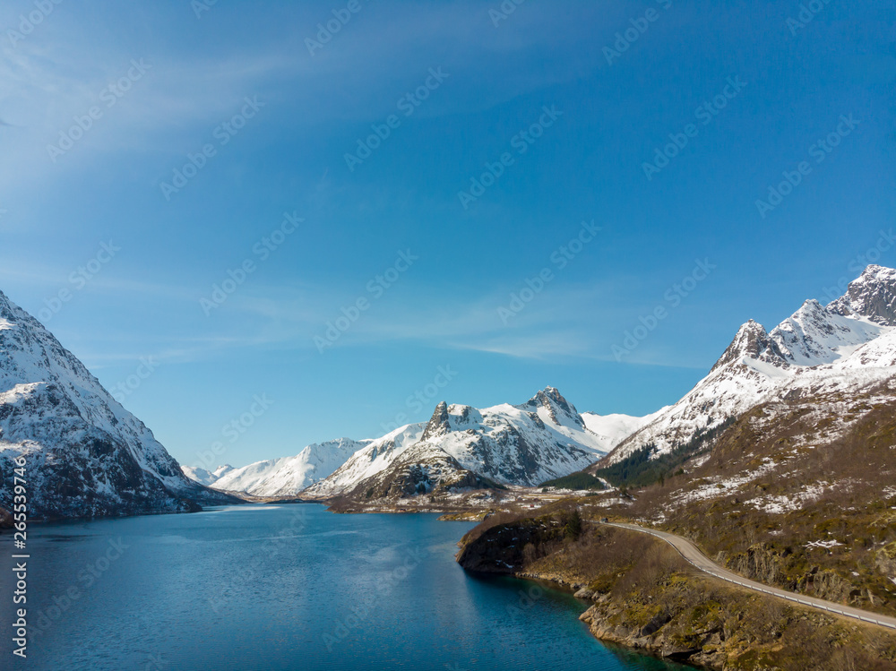 Road along fjord and mountain with snow cap in Norway