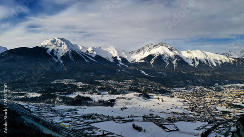 Panoramic aerial view of idyllic winter wonderland mountain Alps on a sunny day with blue sky. Imst, Austria.
