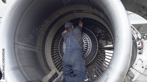 Engineer, technician examines the jet engine with a flashlight. The repair of aircraft in the hangar. Maintenance of aircraft. 4k