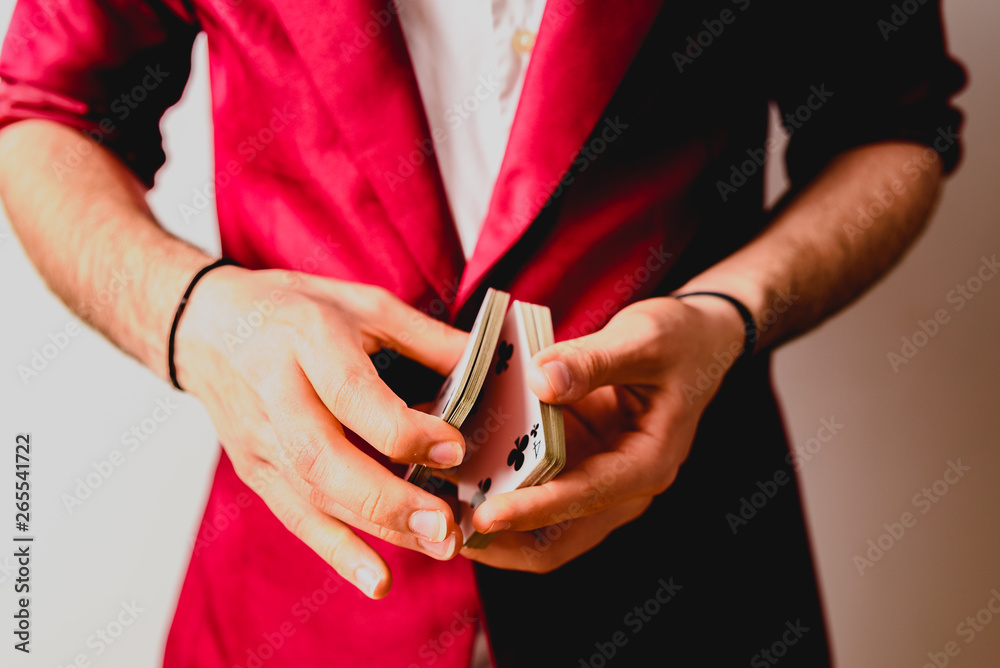 Young magician juggling a deck of playing cards.