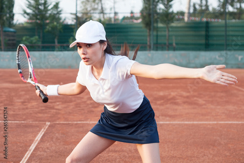young women playing tennis at court © izzetugutmen