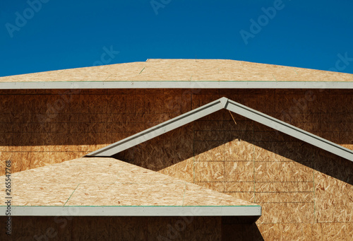 Low angle view of chip board walls of house under construction photo