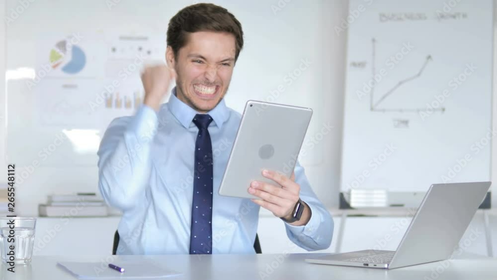 Young Businessman Excited for Results on Tablet