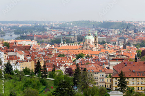 Spring Prague City with St. Nicholas' Cathedral and green Nature with flowering Trees from the Hill Petrin, Czech Republic © Kajano