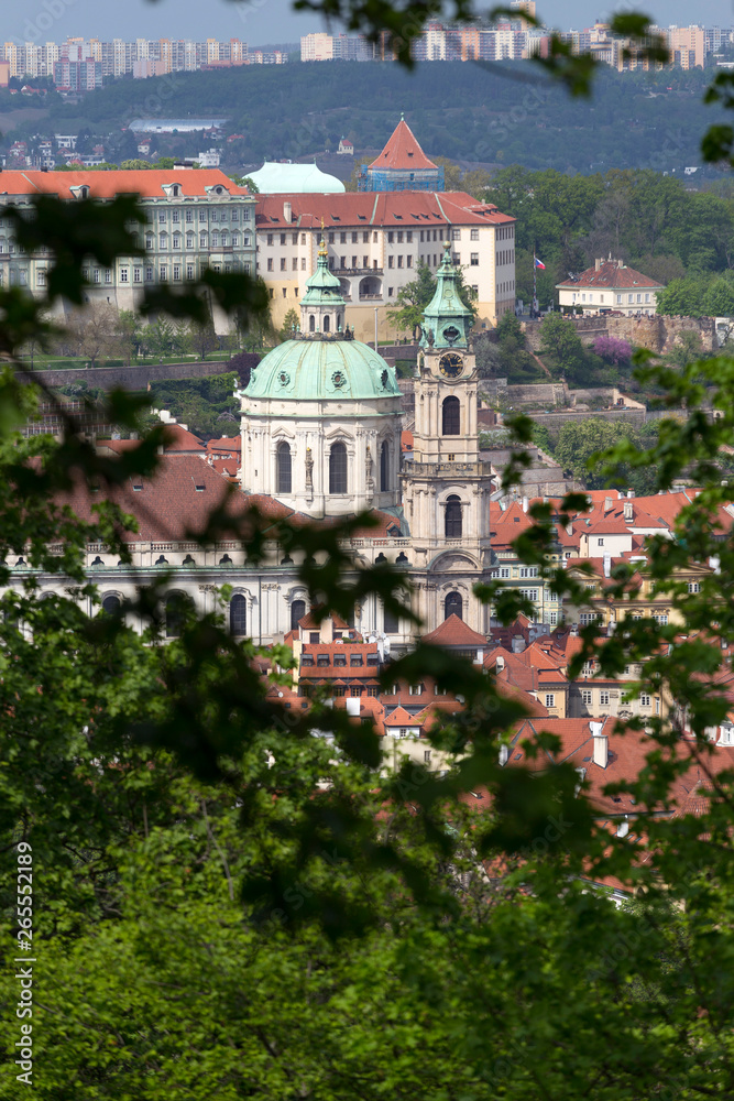 Spring Prague City with St. Nicholas' Cathedral and green Nature with flowering Trees from the Hill Petrin, Czech Republic