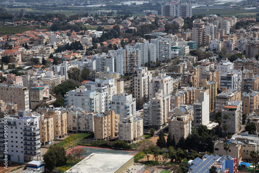 Naklejka premium Aerial view of a residential neighborhood in a city during a cloudy and sunny day. Taken in Netanya, Center District, Israel.