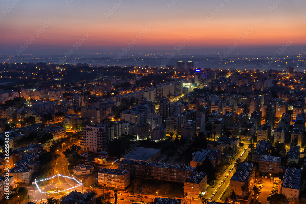 Obraz premium Aerial view of a residential neighborhood in a city during a vibrant and colorful sunrise. Taken in Netanya, Center District, Israel.