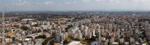 Aerial panoramic view of a residential neighborhood in a city during a cloudy and sunny day. Taken in Netanya, Center District, Israel.