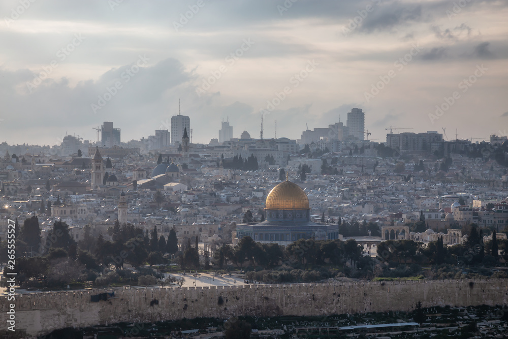 Beautiful aerial view of the Old City and Dome of the Rock during a sunny and cloudy evening. Taken in Jerusalem, Capital of Israel.