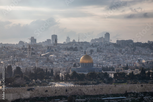 Beautiful aerial view of the Old City and Dome of the Rock during a sunny and cloudy evening. Taken in Jerusalem, Capital of Israel.