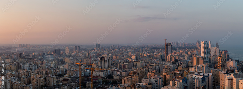 Aerial panoramic view of a residential neighborhood in a city during a vibrant and colorful sunrise. Taken in Netanya, Center District, Israel.