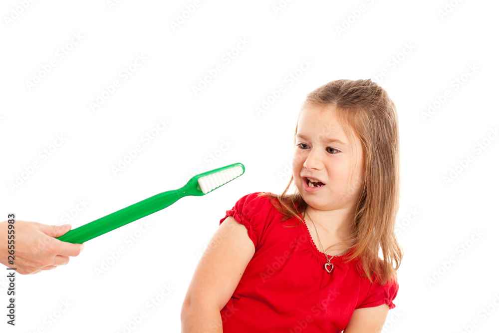 Disgusted Girl Avoiding Large Toothbrush Being Handed to Her Disgusted Girl Avoiding Large Toothbrush Being Handed to Her