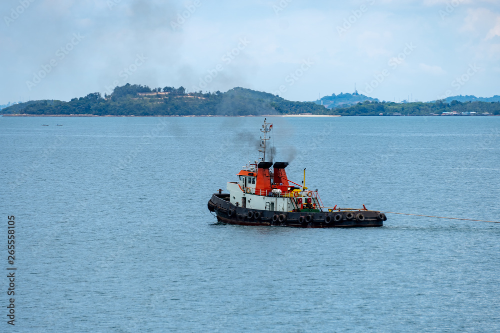 Tug boat tows bulk cargo lighter barge along Singapore strait