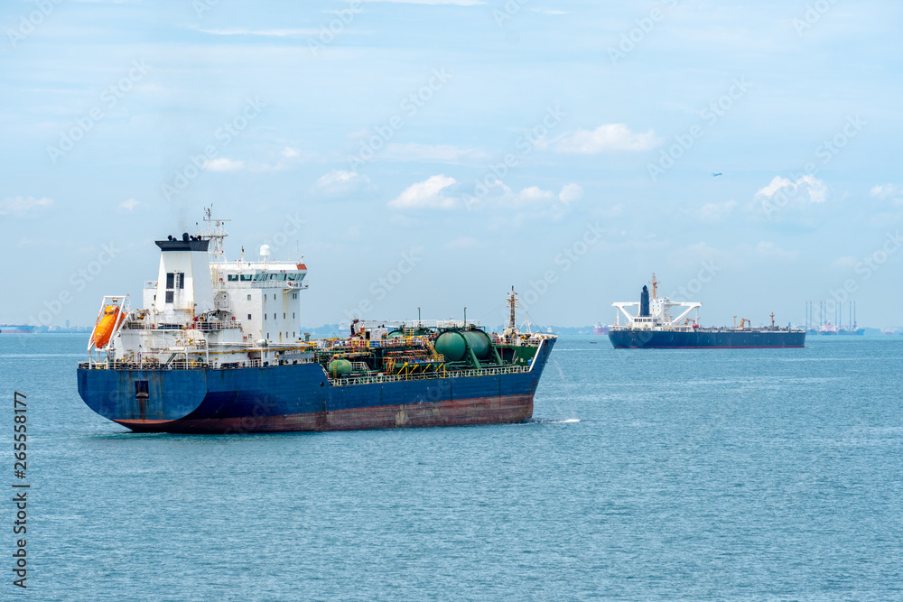 Oil or Chemical Tankers sail in the Singapore strait with commercial aircraft flies over the sky. Oil or Chemical Tankers sail in the Singapore strait with commercial aircraft flies over the sky.