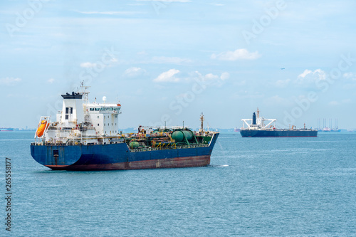 Photography Oil or Chemical Tankers sail in the Singapore strait with commercial aircraft flies over the sky