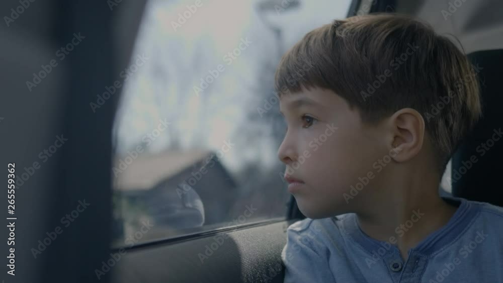 CU of a boy looking through the car window while driving