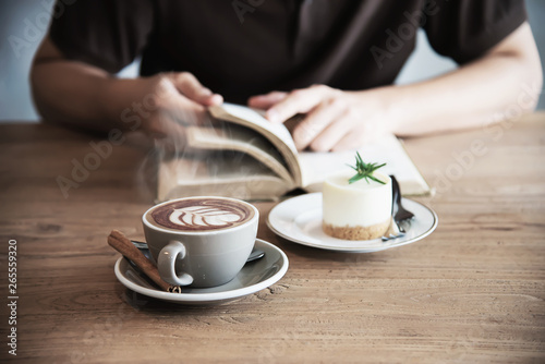 Relax Asian man drink coffee and read book in a modern style coffee shop - people with coffee cup easy lifestyle concept