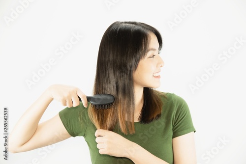 Young beautiful lady happy using comb to straight her hair - woman beauty hair care concept