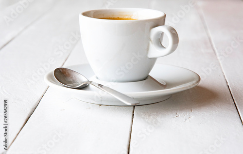 A cup of espresso on white painted boards.
