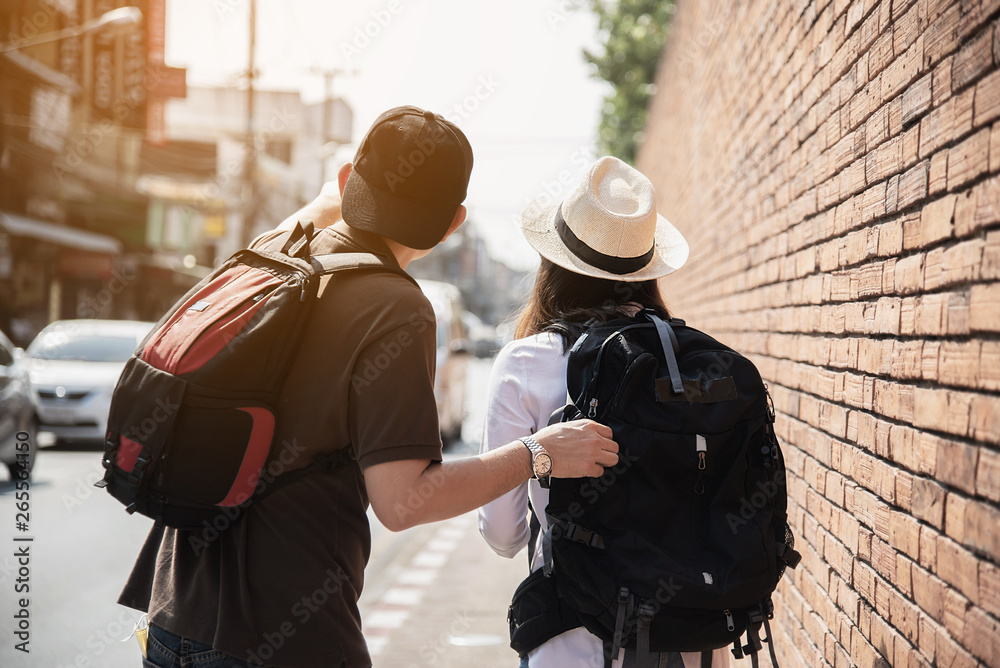 Asian backpack couple tourist holding city map crossing the road - travel people vacation lifestyle concept Asian backpack couple tourist holding city map crossing the road - travel people vacation lifestyle concept