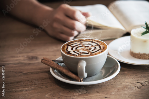 Relax Asian man drink coffee and read book in a modern style coffee shop - people with coffee cup easy lifestyle concept