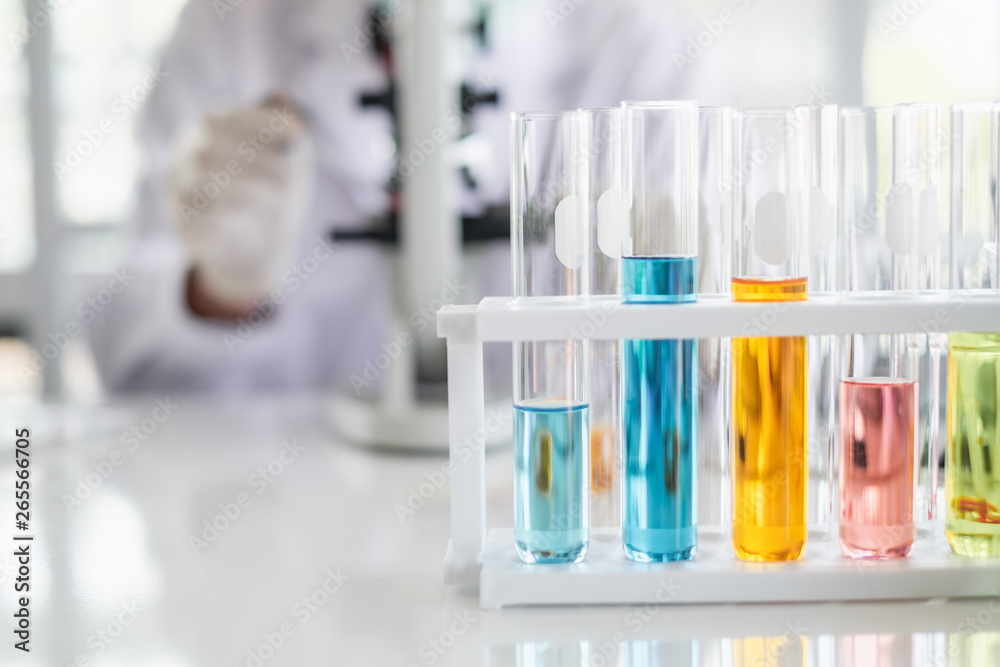 A scientist hands working in laboratory with test tube microscope and solutions. A scientist hands working in laboratory with test tube microscope and solutions.