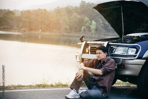 Man try to fix a car engine problem on a local road Chiang mai Thailand - people with car problem transportation concept