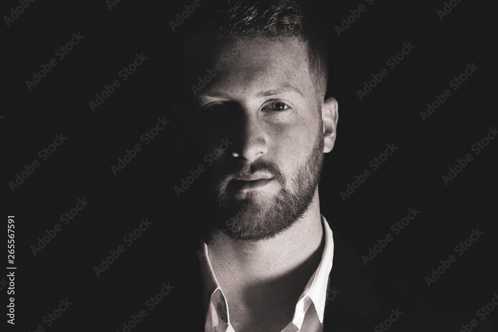 Handsome man with beard is watching you from the shadows Handsome man with beard is watching you from the shadows