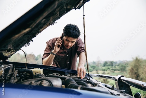 Man try to fix a car engine problem on a local road Chiang mai Thailand - people with car problem transportation concept