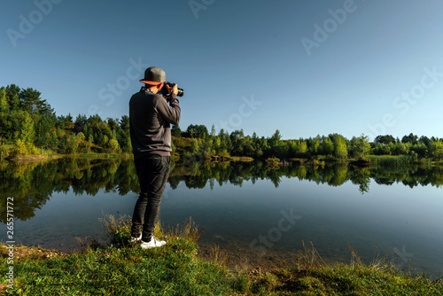 Young man taking pictures of a lake