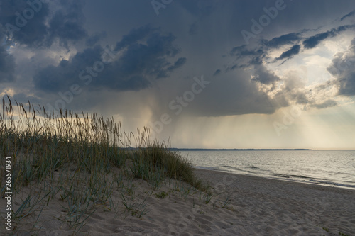 Wild sandy beach against scenic stormy clouds