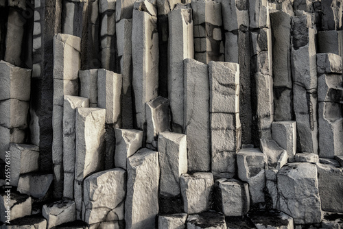 Column of basalt stone in The black sand beach of Reynisfjara and the mount Reynisfjall from the Dyrholaey promontory in the southern coast of Iceland.