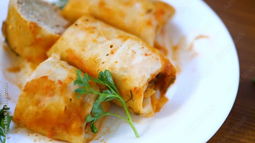 stewed cabbage rolls with meat filling inside in a plateon a wooden table stewed cabbage rolls with meat filling inside in a plateon a wooden table