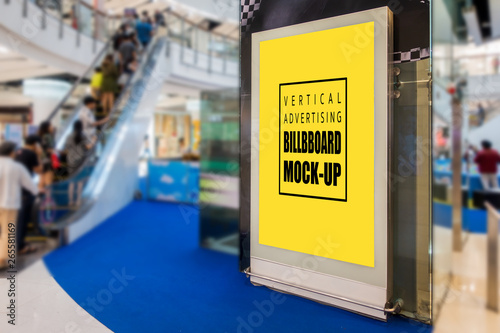 Mock up perspective vertical blank billboard advertising on the wall near escalator in shopping mall with clipping path, blurred people in background, empty space for insert media or text information