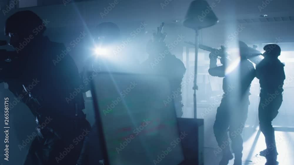 Masked Team of Armed SWAT Police Officers Slowly Move in a Hall of a Dark Seized Office Building with Desks and Computers. Soldiers with Rifles and Flashlights Surveil and Cover Surroundings. Masked Team of Armed SWAT Police Officers Slowly Move in a Hall of a Dark Seized Office Building with Desks and Computers. Soldiers with Rifles and Flashlights Surveil and Cover Surroundings.