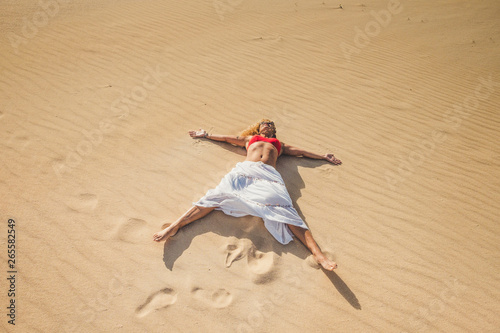 Beautiful caucasian woman enjoying summer holiday vacation travel lay down at the beach on the sand dunes having a sunbath - freedom and happiness lifestyle people outdoor in the nature © simona