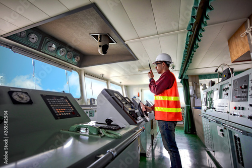 duty officer in charge handle of the ship navigating to the port destination, navigation on the bridge of the ship vessel under voyage sailing to the sea photo