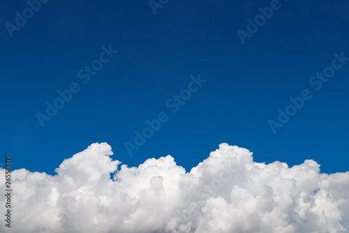 Background, clear blue sky and white cumulus fluffy clouds on the bottom edge photo