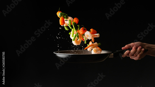 Fototapeta Naklejka Na Ścianę i Meble -  Sea food cooking shrimp with vegetables, on a dark background