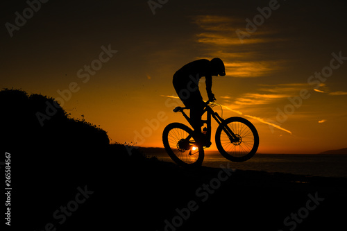 silhouette of cyclist on background of sunset sky