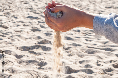 Sand pours from the hands of girls