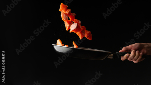 Seafood, Professional cook prepares pieces of red fish, salmon, trout. Frost in the air, Cooking seafood, healthy vegetarian food and food on a dark background. Horizontal view