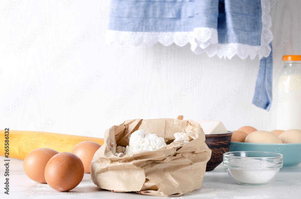 Closeup of paper bagfull of flour, eggs and salt- key ingredients for dough.Rural mood, grandmother's kitchen