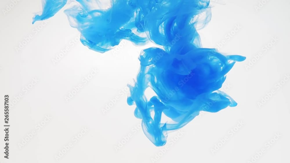 Blue acrylic paint dropped into water and recorded while dissolving, close shot. Blurred background. Abstract swirl of blue paint in liquid. Abstract acrylic splash in water. Ink in water